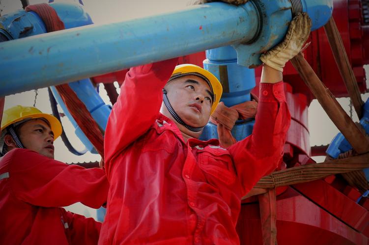 华东石油局油服中心压裂队职工在高温下接压裂管汇.
